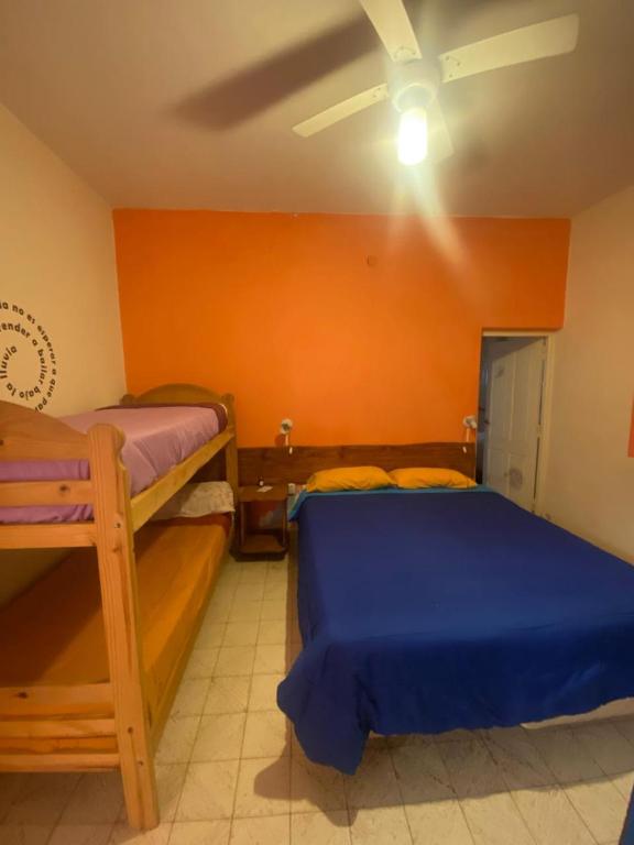a bedroom with two bunk beds and an orange wall at Estrella Vladimir Hostel in Capilla del Monte