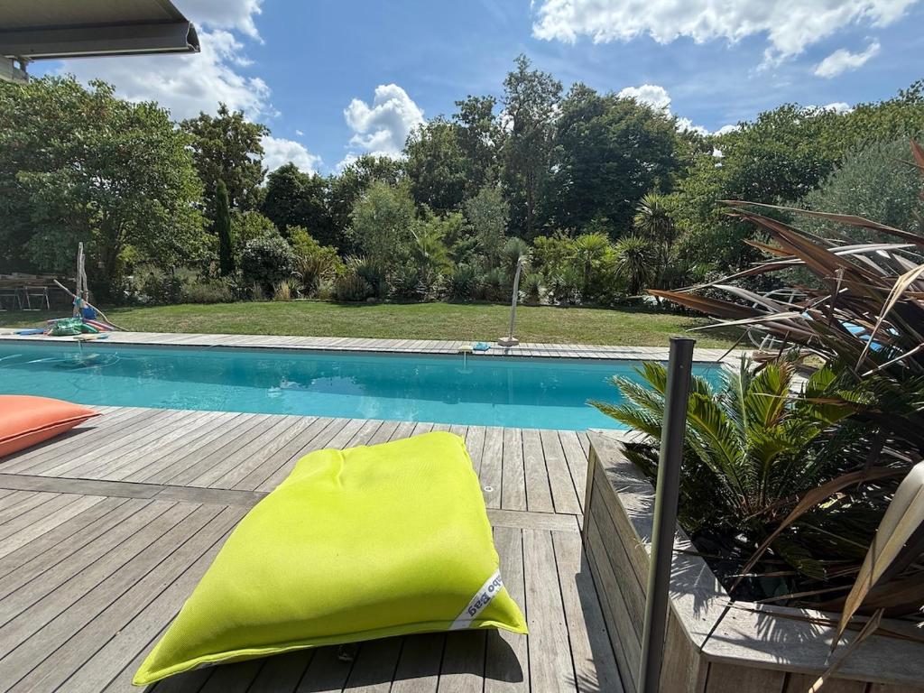 a yellow towel sitting on a deck next to a swimming pool at Alice's Studio and Oasis in Poitiers