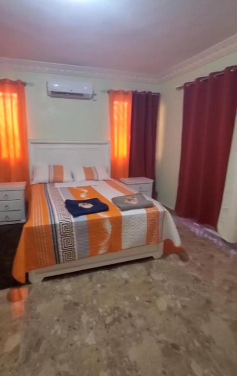 a bedroom with a bed and red curtains at Apartahotel Henry Winche in Sabana Grande de Boyá