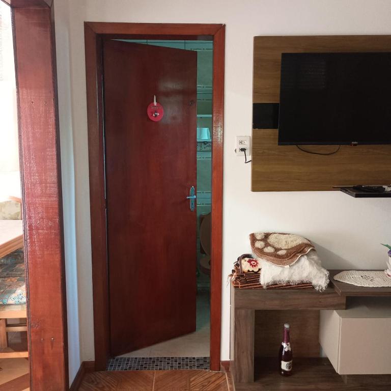 a wooden door in a room with a television at Aluguel Nova Tramandaí in Tramandaí