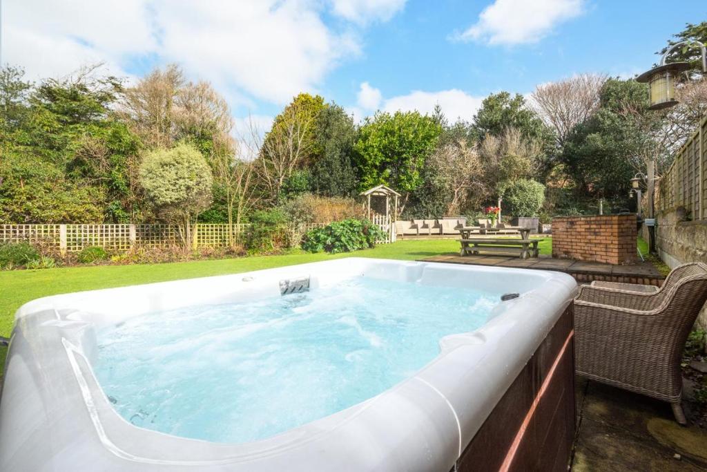 a hot tub in a garden with a fence at 5 Bed in Croyde oc-brambc in Croyde