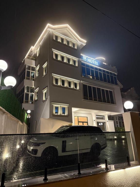a limo parked in front of a hotel at night at Murati Lake View Hotel in Tirana