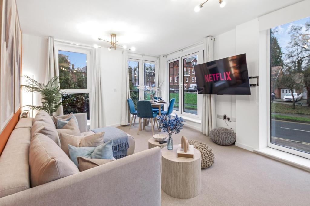 a living room with a couch and a tv at Central Hemel 2-Bed Flat with Secure Parking in Hemel Hempstead