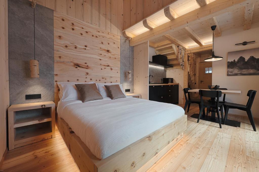 a bedroom with a bed and a table with chairs at Agriturismo La Daga Nature Lodge in Auronzo di Cadore