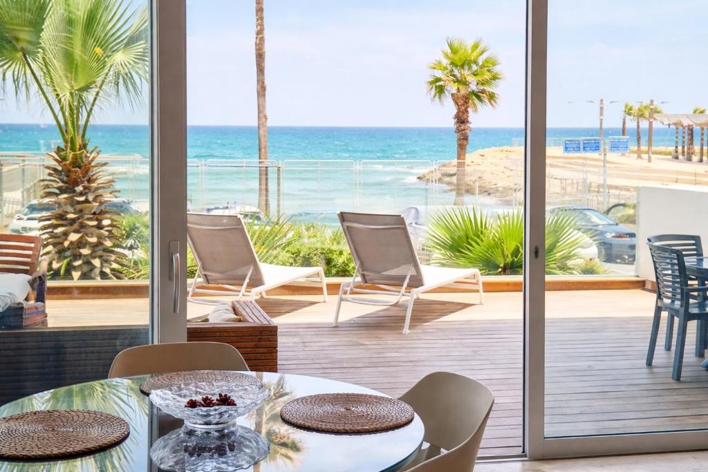 a dining room with a view of the beach at Alonas Apartments Beachfront Apartment in Haifa
