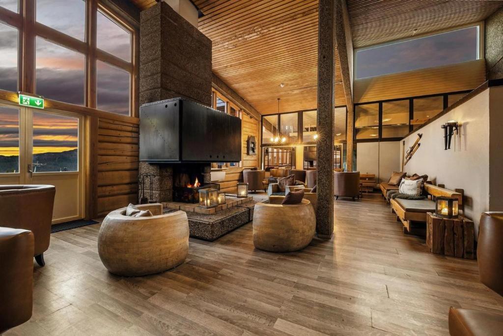 a living room with a fireplace and couches at Spåtind Fjellhotell in Nord Torpa