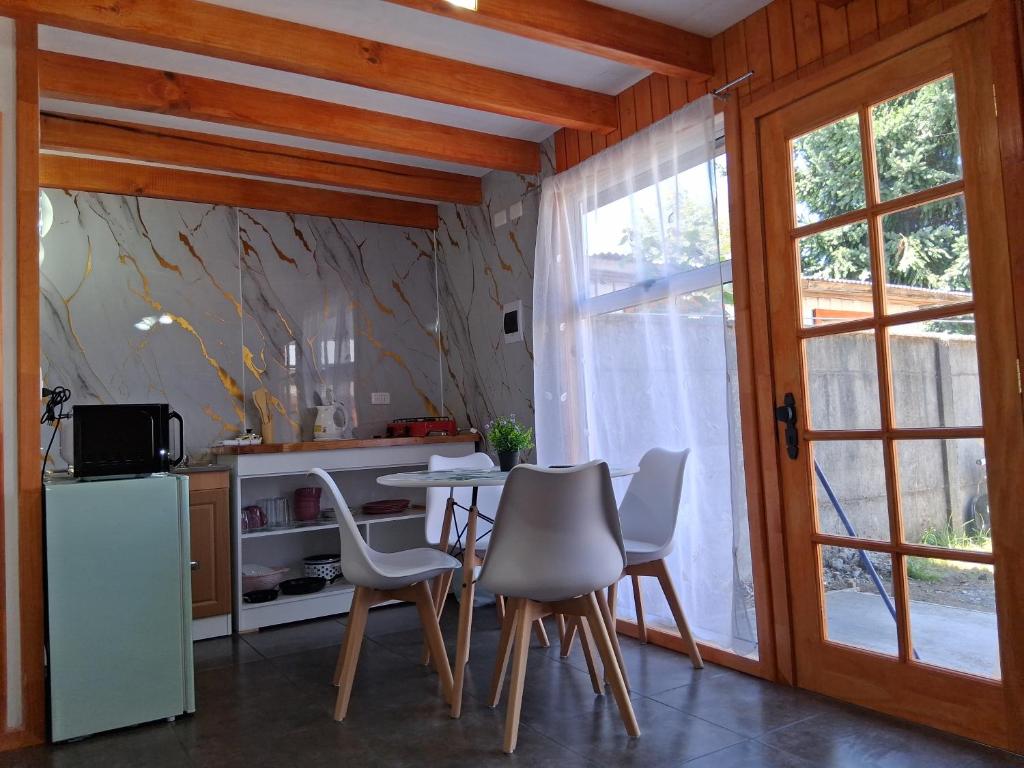 a kitchen and dining room with a table and chairs at Mini departamento 3 in Coñaripe