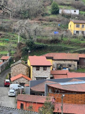 a group of buildings with red roofs on a hill at La Puchera in Cangas del Narcea