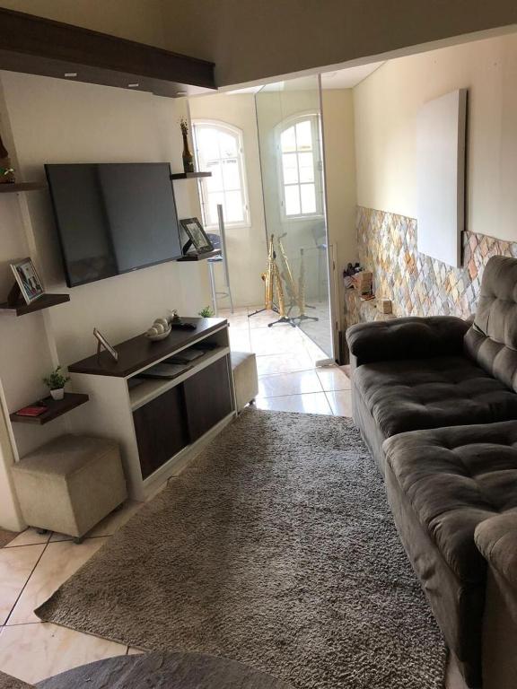 a living room with a couch and a flat screen tv at Castelo Princesa Isabel in Ouro Preto