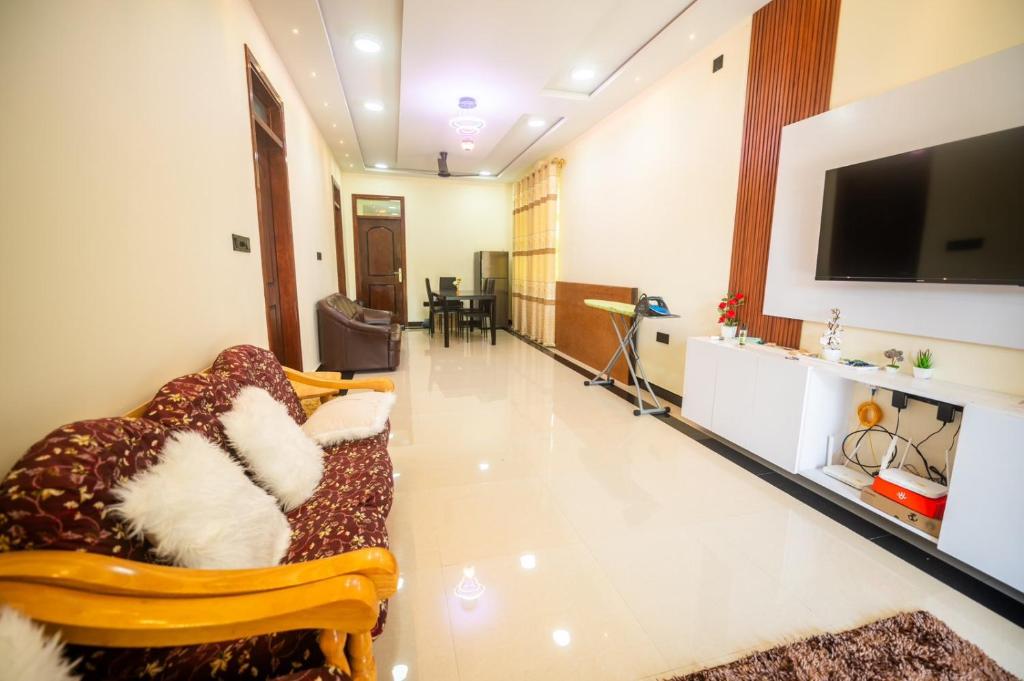 ein Wohnzimmer mit Sofa und Flachbildfernseher in der Unterkunft Azman in Fuvahmulah
