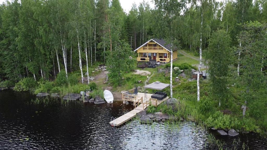 an aerial view of a log cabin on a lake at Huvila Kivitasku - Arkea pakoon in Kutemajärvi