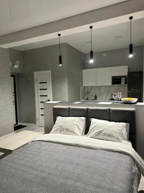 a bedroom with a large bed and a kitchen at Apartments Velora in Kryvyi Rih