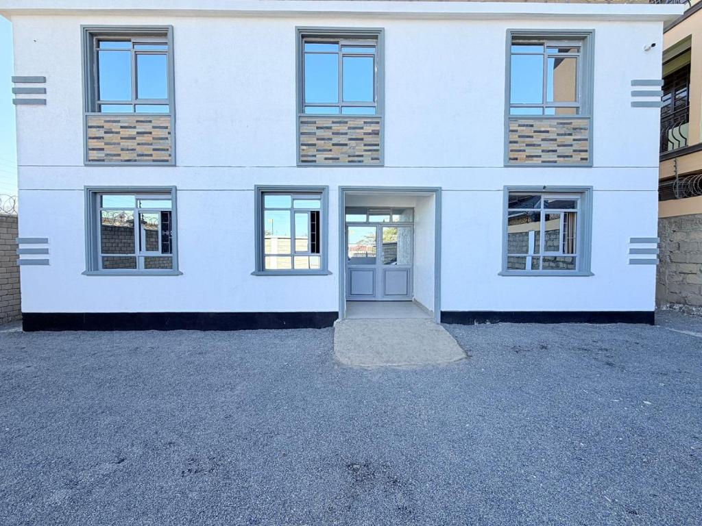 a white building with windows and a door at Sacred Crown Suites in Naivasha