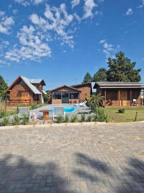 a house with a swimming pool in front of it at Cabanas das Oliveiras in Torres