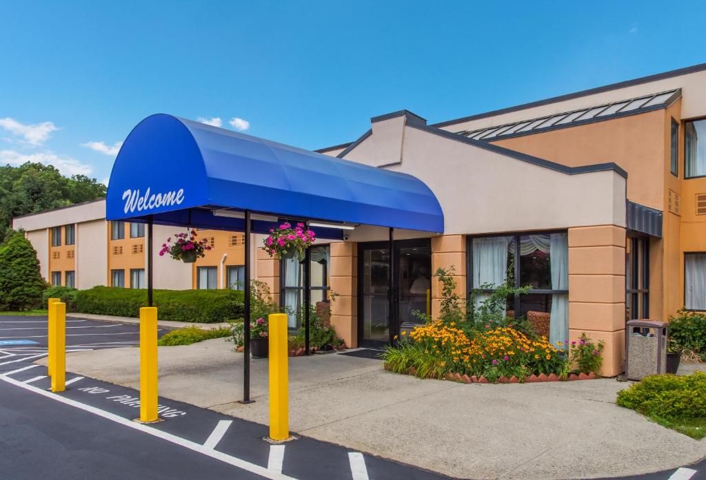 a hotel with a blue awning in a parking lot at All Seasons Inn & Suites Smithfield Providence in Smithfield