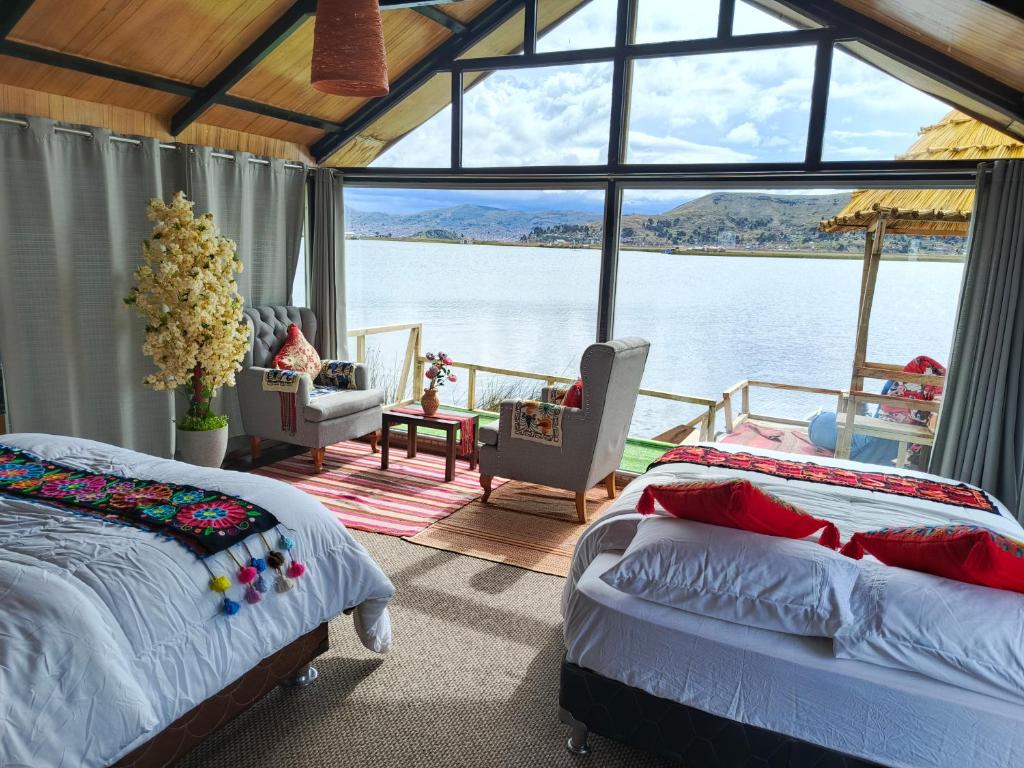 two beds in a room with a view of the water at INTI UTA titicaca in Puno