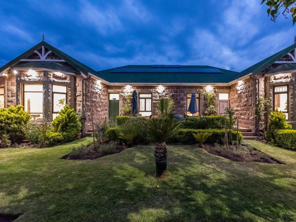 a brick house with lights on the front yard at Lilla-Bett Self Catering Mossel Bay in Mossel Bay