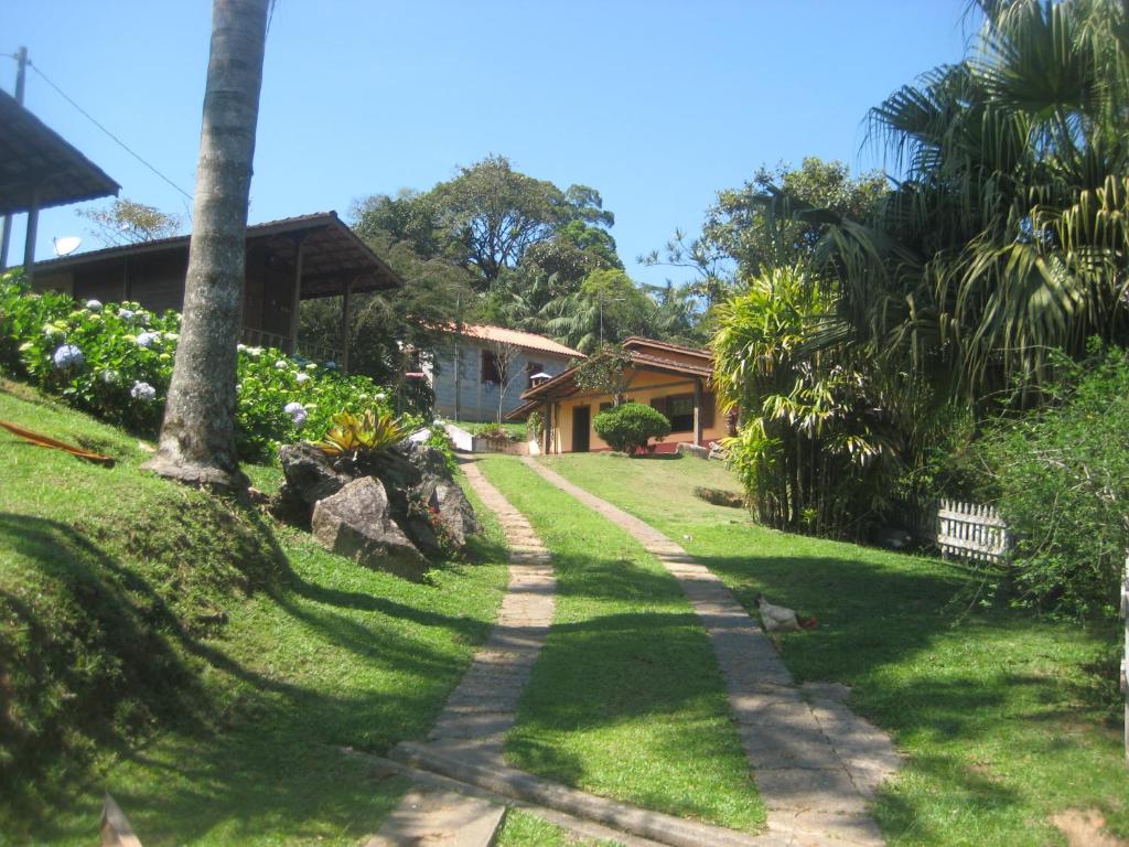 a path leading to a house with a palm tree at Pousada Recanto dos Pinheiros in Pilar do Sul