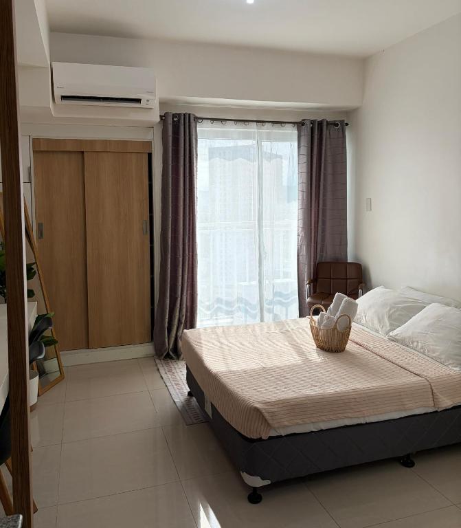 ein Schlafzimmer mit einem großen Bett und einem Fenster in der Unterkunft Condo Saga Davao City in Davao City