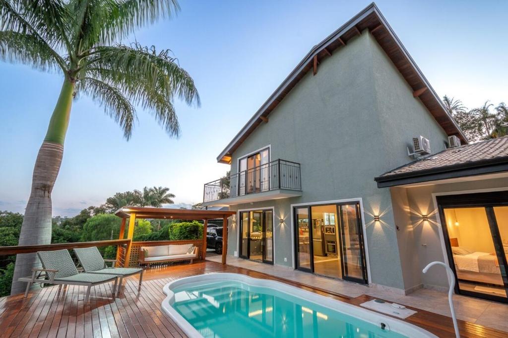 a house with a swimming pool in front of a house at Casa campo moderna e confortável in Itatiba