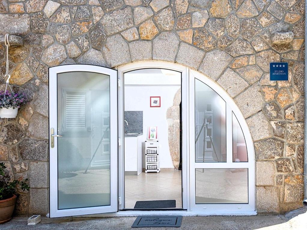 an entrance to a stone building with two glass doors at Apartment Sweet Studio in Punat