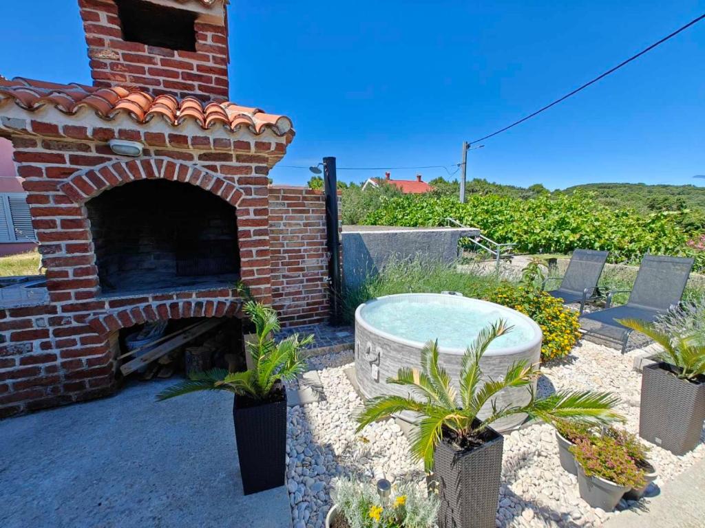 a brick patio with a table and a brick oven at House Dawn in Rab