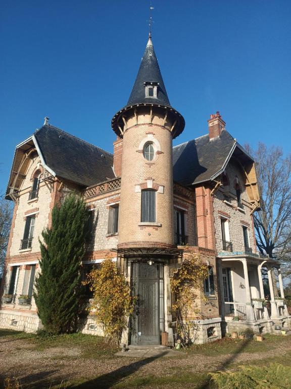 an old house with a tower on top of it at Le Cottage des chats in Beaulieu-sur-Loire