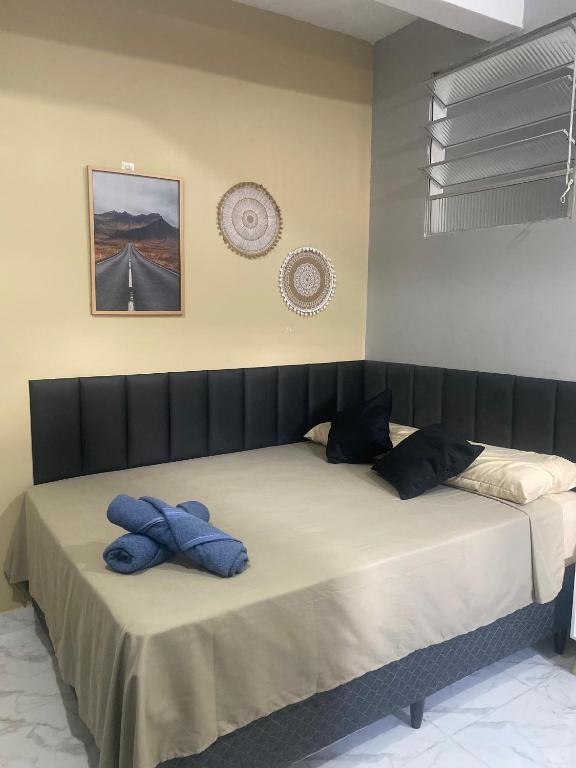 a bedroom with a large bed with blue pillows on it at Espaço completo no Umarizal centro de Belém in Belém