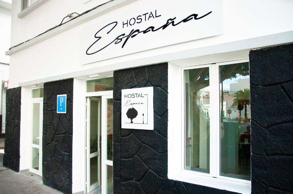 a store with a sign on the side of a building at Hostal España in Arrecife