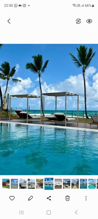 a picture of a swimming pool with palm trees at Cais Eco Residência in Ipojuca