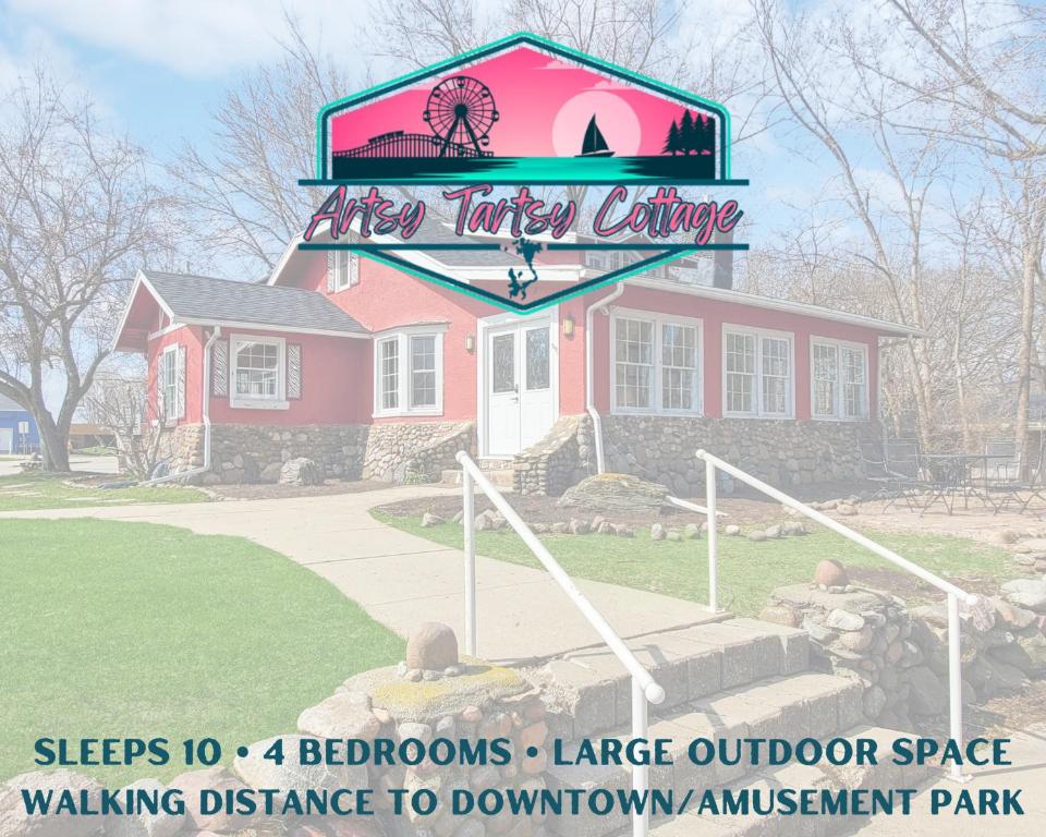 a sign in front of a pink house at 127 Hwy 71 Main House in Arnolds Park
