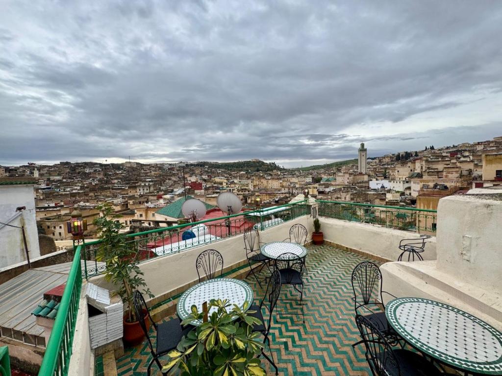 a balcony with tables and chairs and a view of a city at Dar Karaouyine Panoramic in Fez