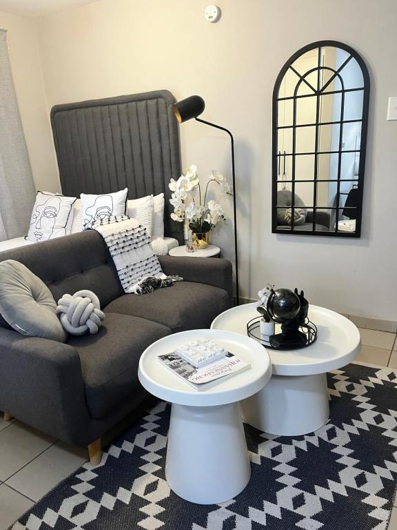 a living room with a couch and two tables at B-Hive at Devland Room 3 in Soweto