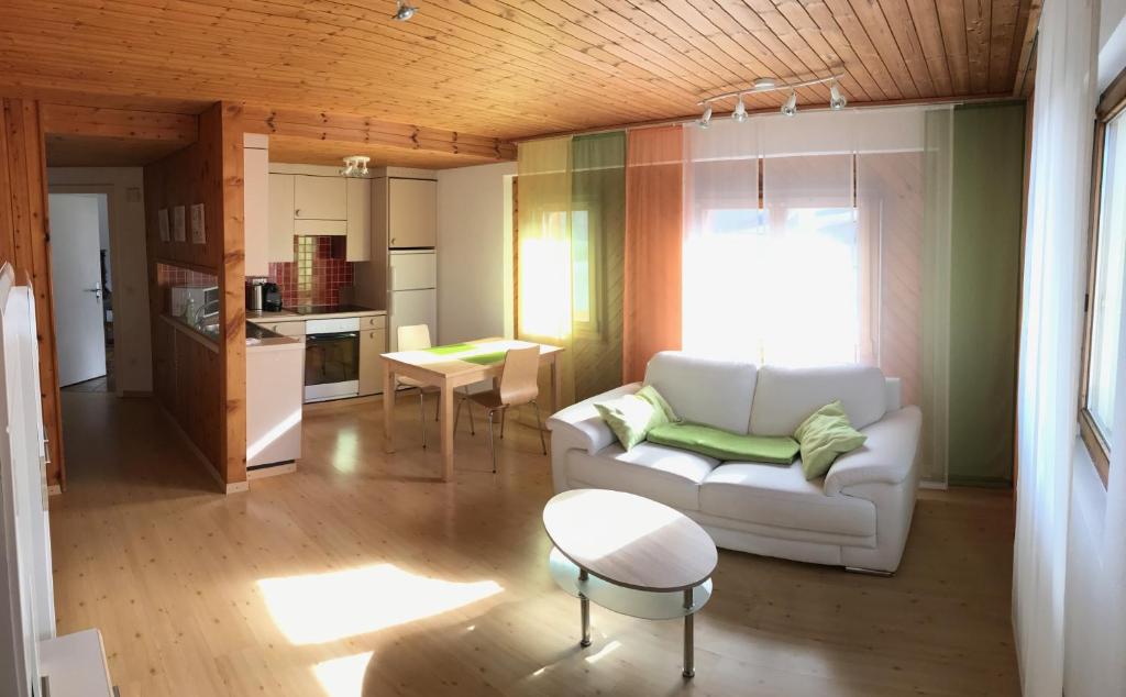 sala de estar con sofá blanco y mesa en Appartement Rietli en Triesenberg