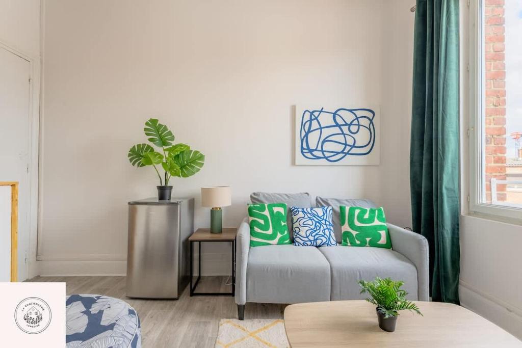 a living room with a gray couch with green pillows at Cosy flat, Duplex, proche centre ville in Lens