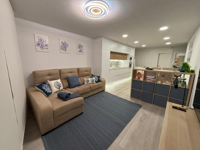 a living room with a couch and a kitchen at Marea in Sanxenxo