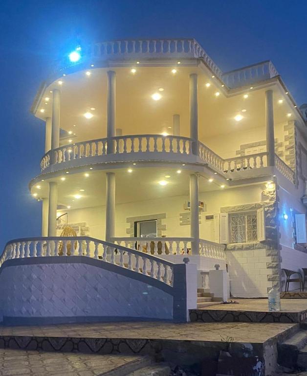 a large white house with a balcony at night at Duplex Villa 4 rooms in Marsa Matruh