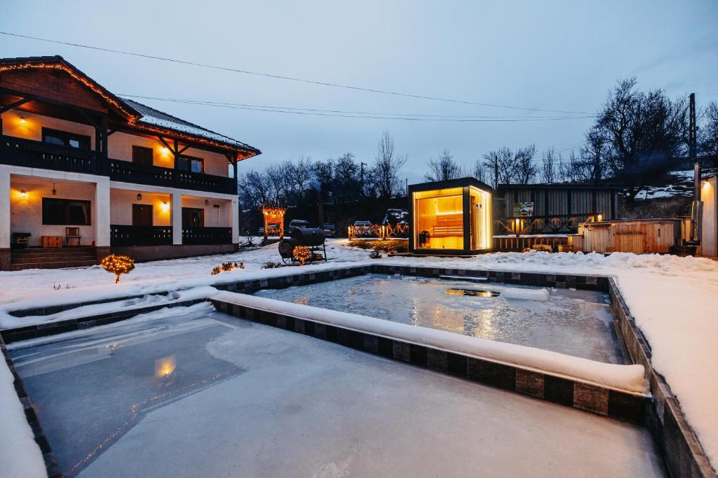a swimming pool covered in snow in front of a house at Biscontini's Studio in Praid