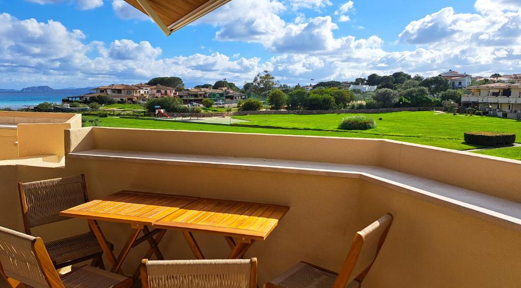 a small balcony with a wooden table and chairs at Smeralda Apartment - Golfo Aranci in Golfo Aranci
