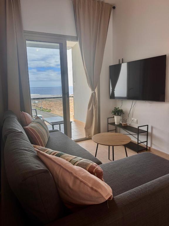 a living room with a couch and a large window at Rosalia28 in Antigua