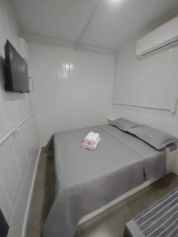 a small bedroom with a bed with two pillows at Loft Navegantes Próximo Aeroporto e BR 101 in Navegantes