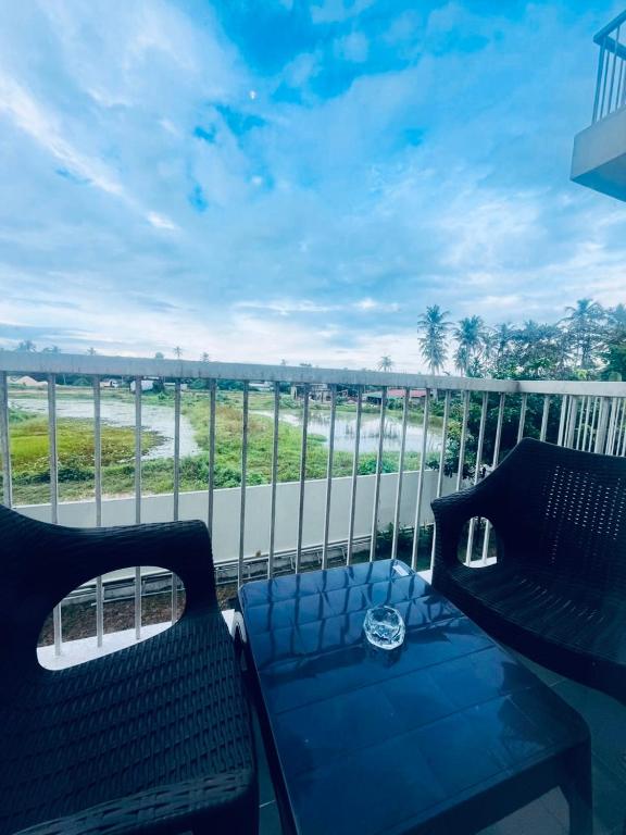 a balcony with two benches and a view of the ocean at Santorini Transit hotel in Negombo
