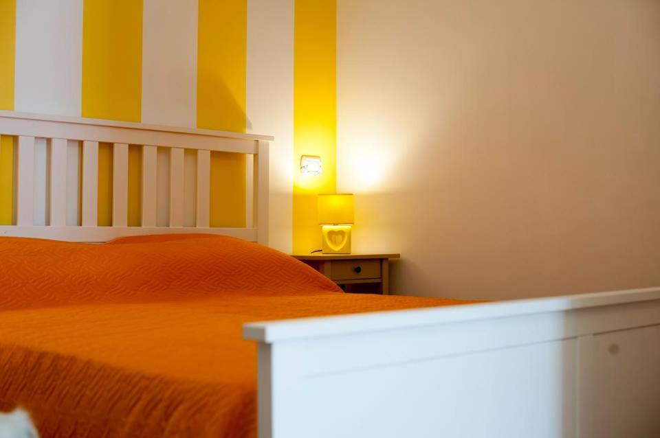Un dormitorio con una cama naranja con rayas amarillas y blancas en O' Paese E Masaniello, en Nápoles