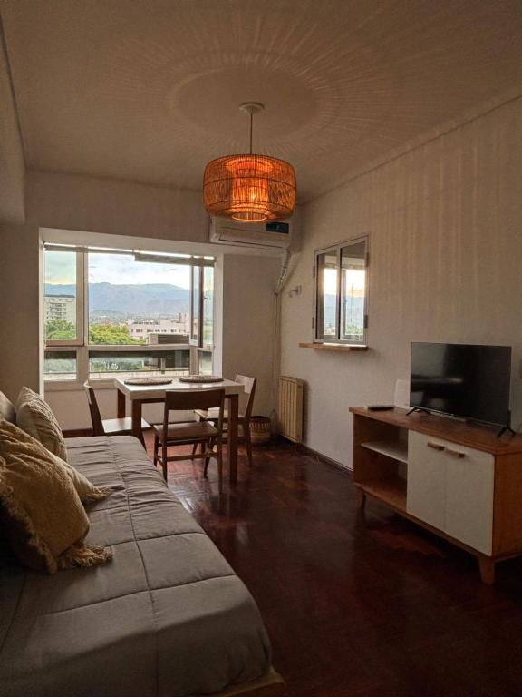 a living room with a bed and a table with a television at La Plaza Apart in Mendoza