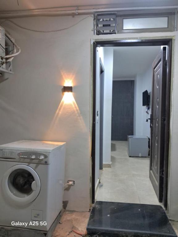 a washing machine in a room with a light on the wall at Hayat Pyramids House DBL 59S in ‘Ezbet `Abd el-Ḥamîd
