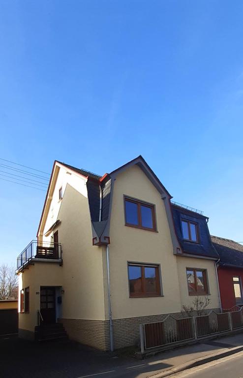 a white house with a gambrel roof at Haus am Bach in Miehlen