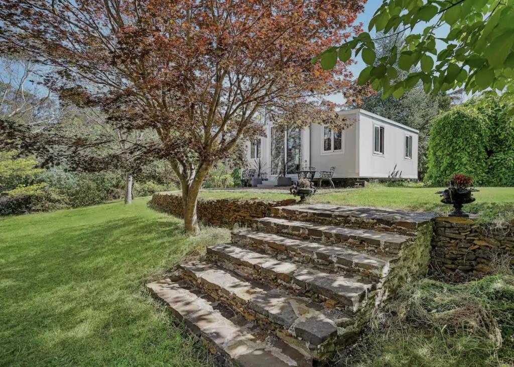 a garden with a tree and a house at Cosy Mountain Cabin in Lawson