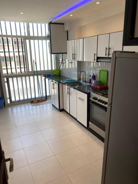 a kitchen with white appliances and a large window at Miloche home in Oulad Akkou