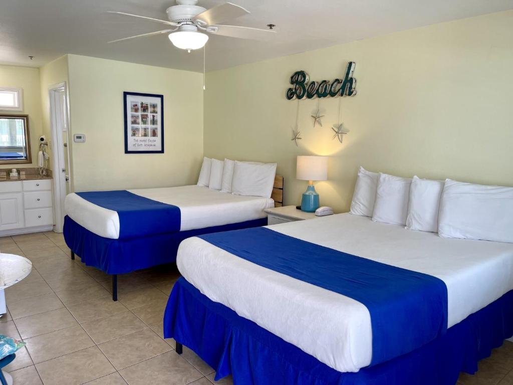 a bedroom with two beds with blue and white sheets at Beachgate Condo Suites and Hotel 436 condo in Port Aransas