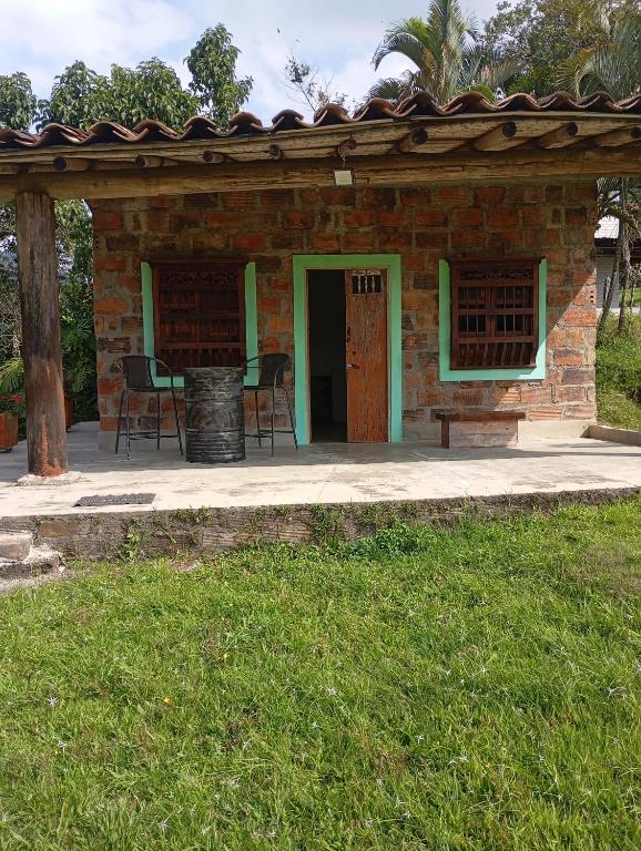 a brick house with a table and chairs in a yard at La Luna cabin in Amagá